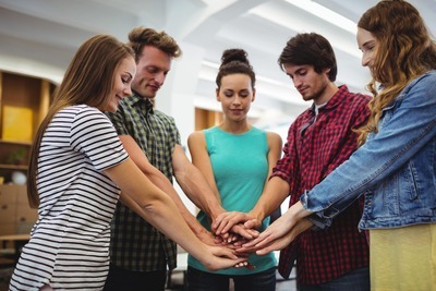 business-executives-with-hand-stacked-min